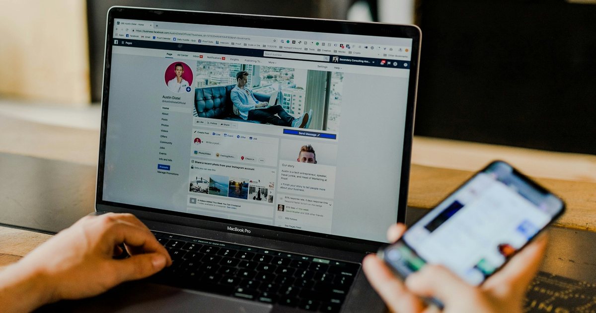 Hands on a laptop and a phone, checking an ad