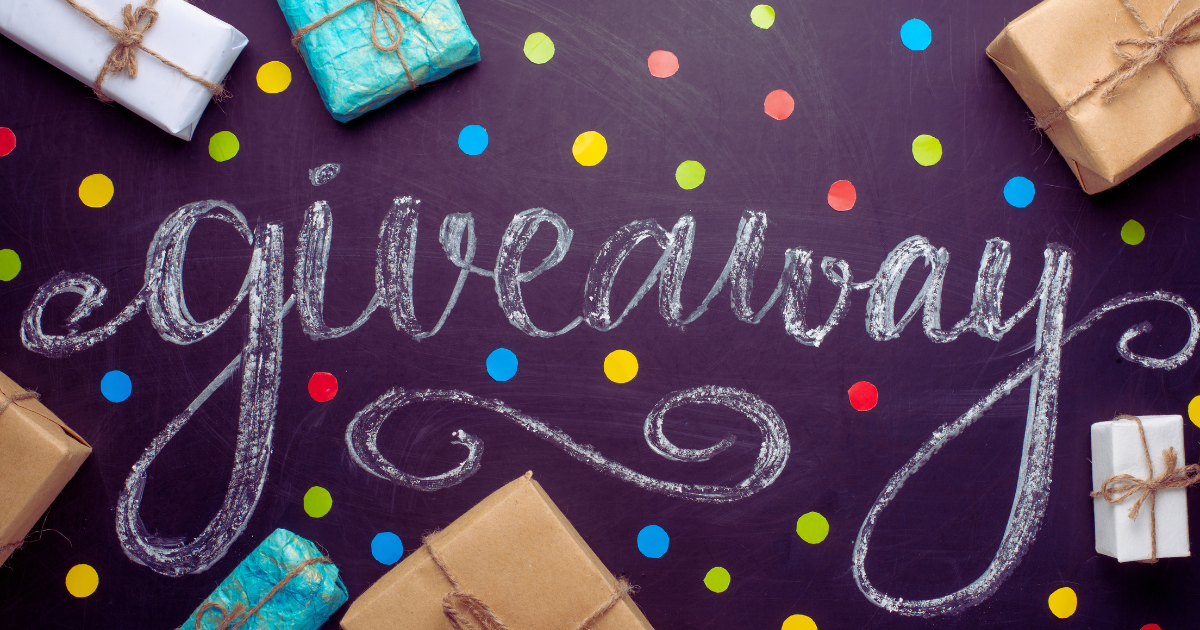 Giveaway written in chalk on a blackboard surrounded by wrapped gift boxes and colorful confetti