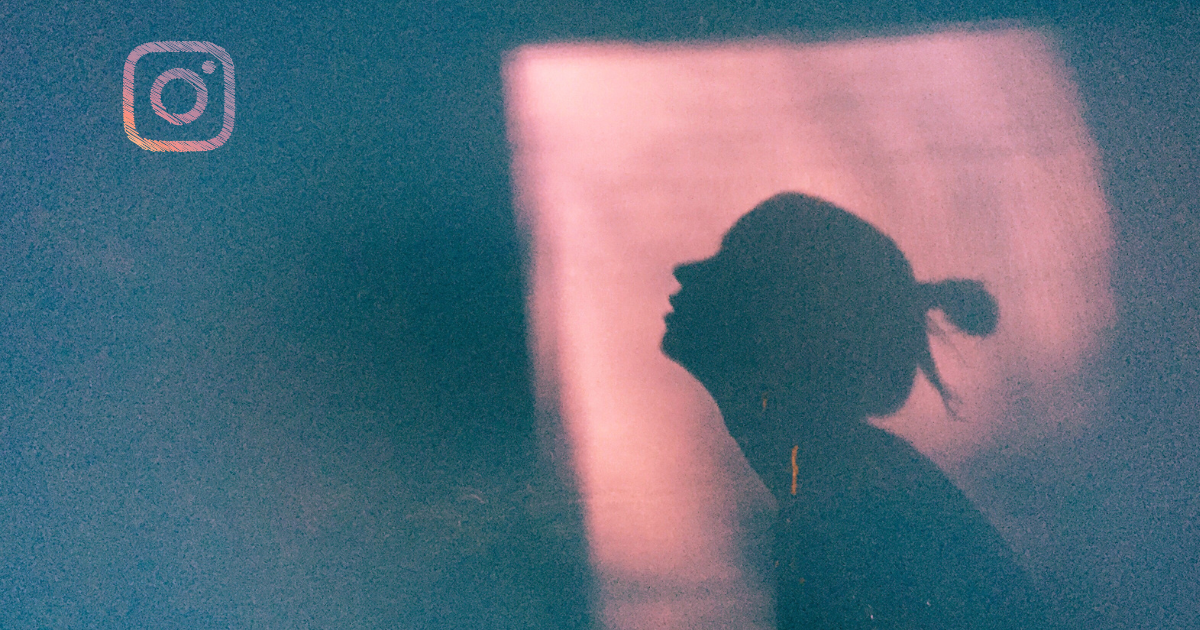 Silhouette of a person hidden in shadow with Instagram logo illustrating Instagram shadowban
