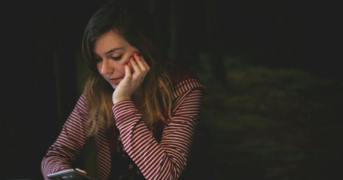 A person reading her phone at a table